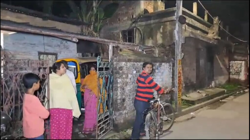 Shadow of Robinson Street in Ichapur Bidhanpalli; Grandfather holds sister's body